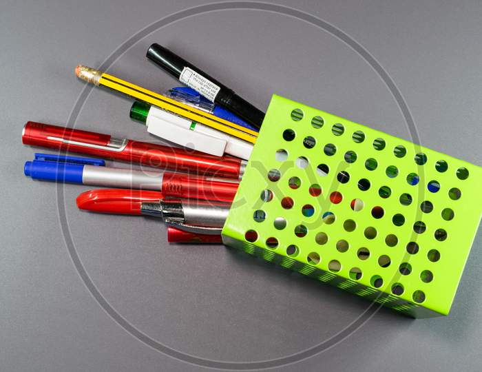 A Fallen Pen And Pencil Holder In Grey Background