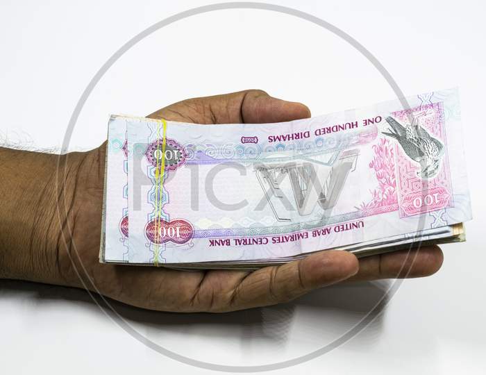 A Man Hand With Full Of Uae Dirhams With White Background, Uae Currency