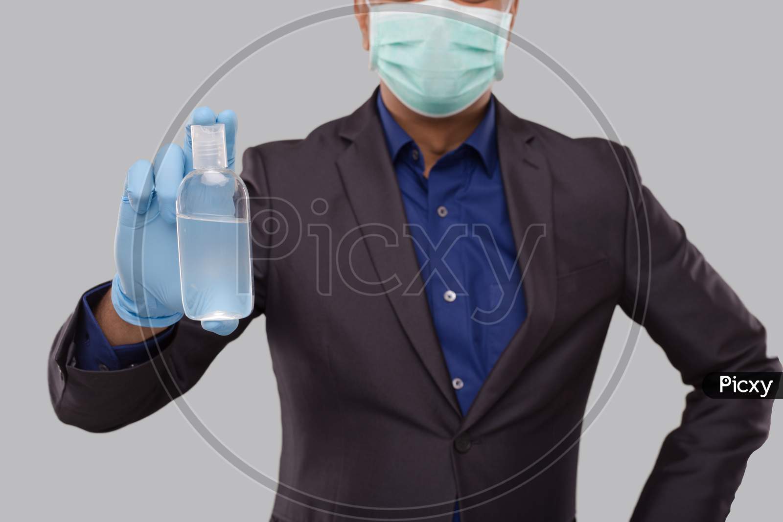 Businessman Showing Hands Sanitizer Wearing Medical Mask And Gloves Close Up. Indian Business Man Holding Hand Antiseptic
