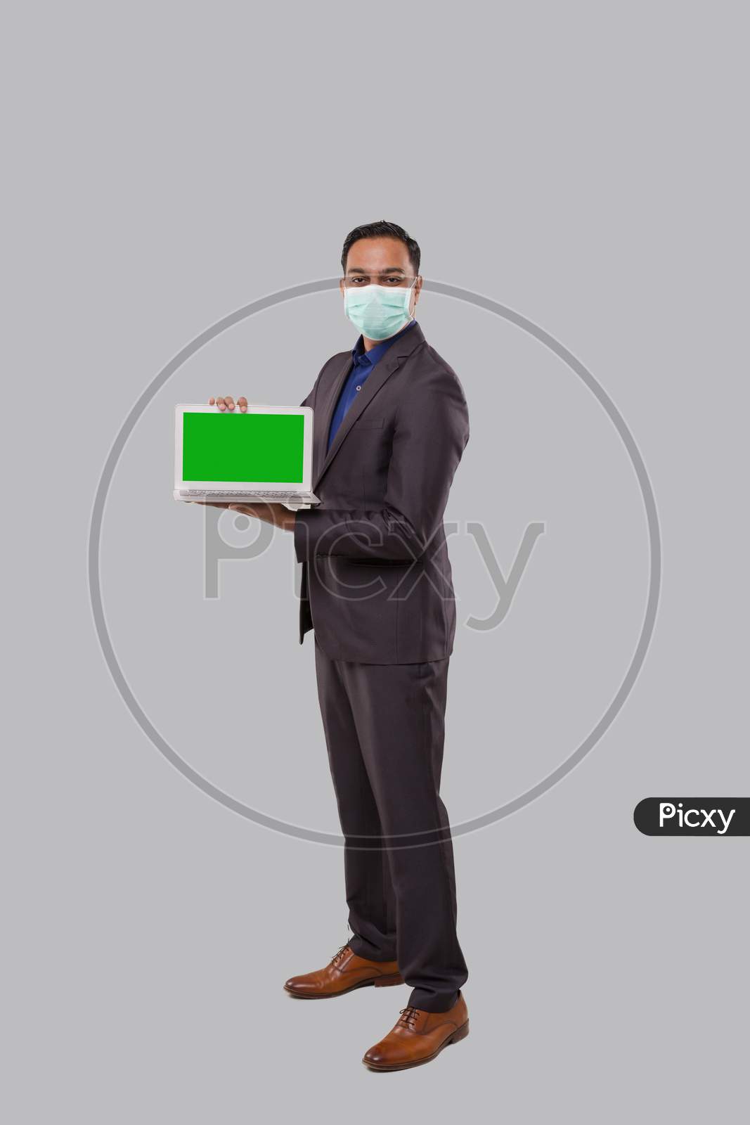 Businessman Showing Laptop Green Screen Isolated Wearing Medical Mask And Gloves. Indian Business Man With Laptop In Hands. Online Business Concept