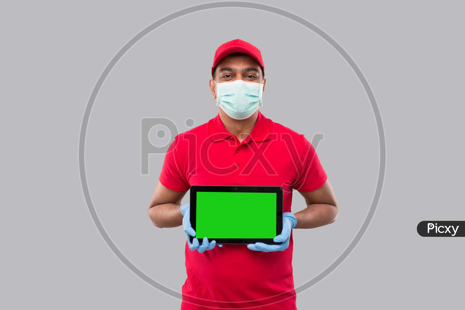 Delivery Man Showing Tablet Wearing Medical Mask And Gloves. Indian Delivery Boy With Tablet In Hands. Home Delivery, Technical Delivery