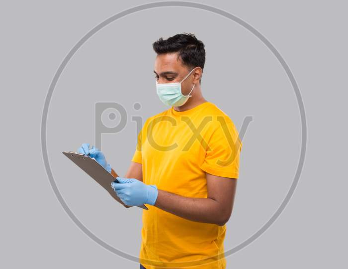Indian Man Writing In Clipboard Wearing Medical Mask And Gloves. Indian Man Clipboard