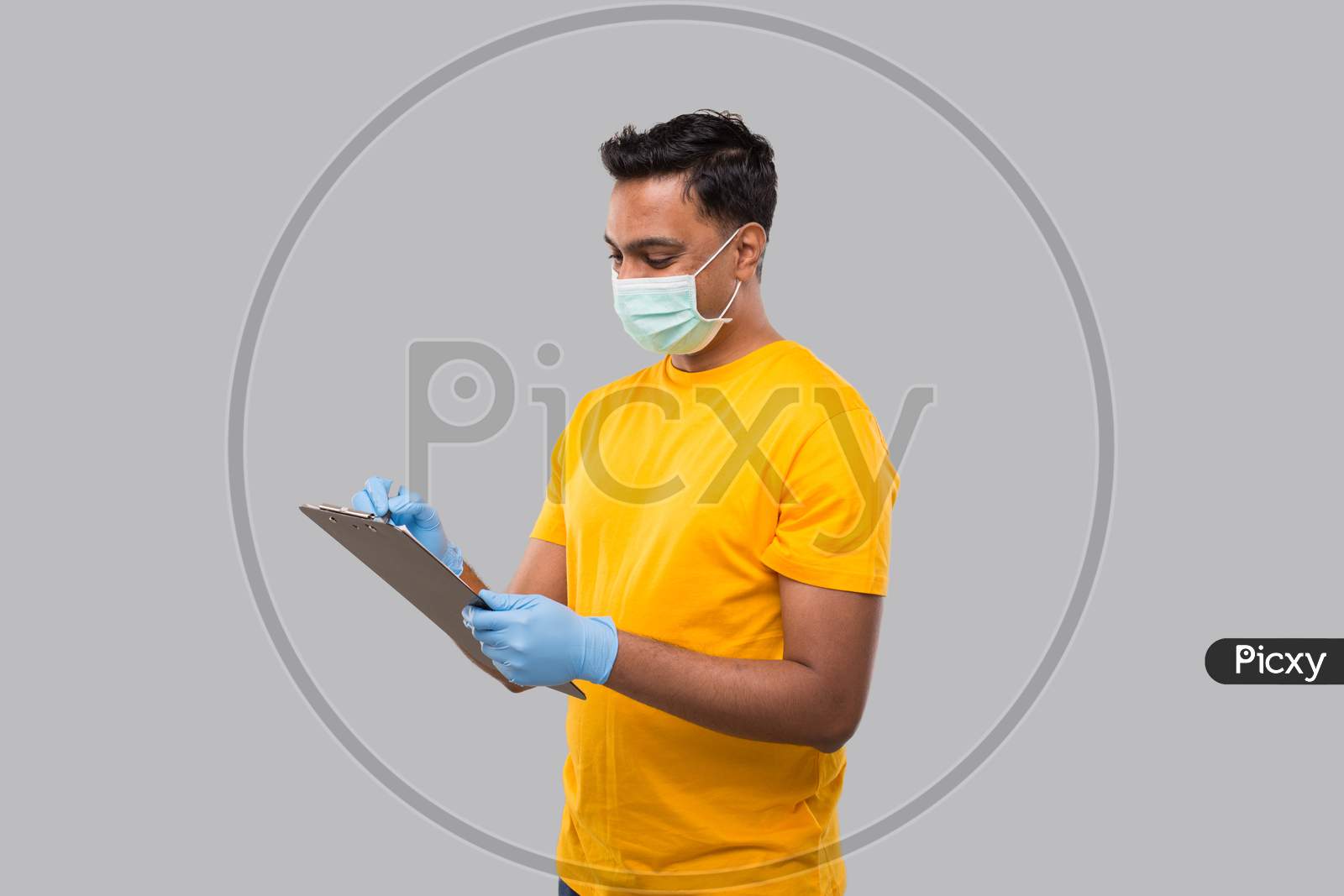 Indian Man Writing In Clipboard Wearing Medical Mask And Gloves. Indian Man Clipboard