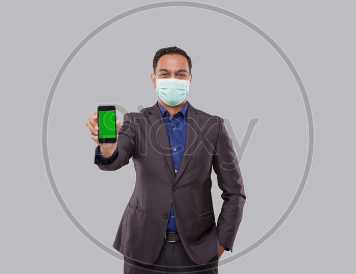 Businessman Showing Phone Wearing Medical Mask. Indian Business Man Technology Business At Home. Phone Green Screen Isolated
