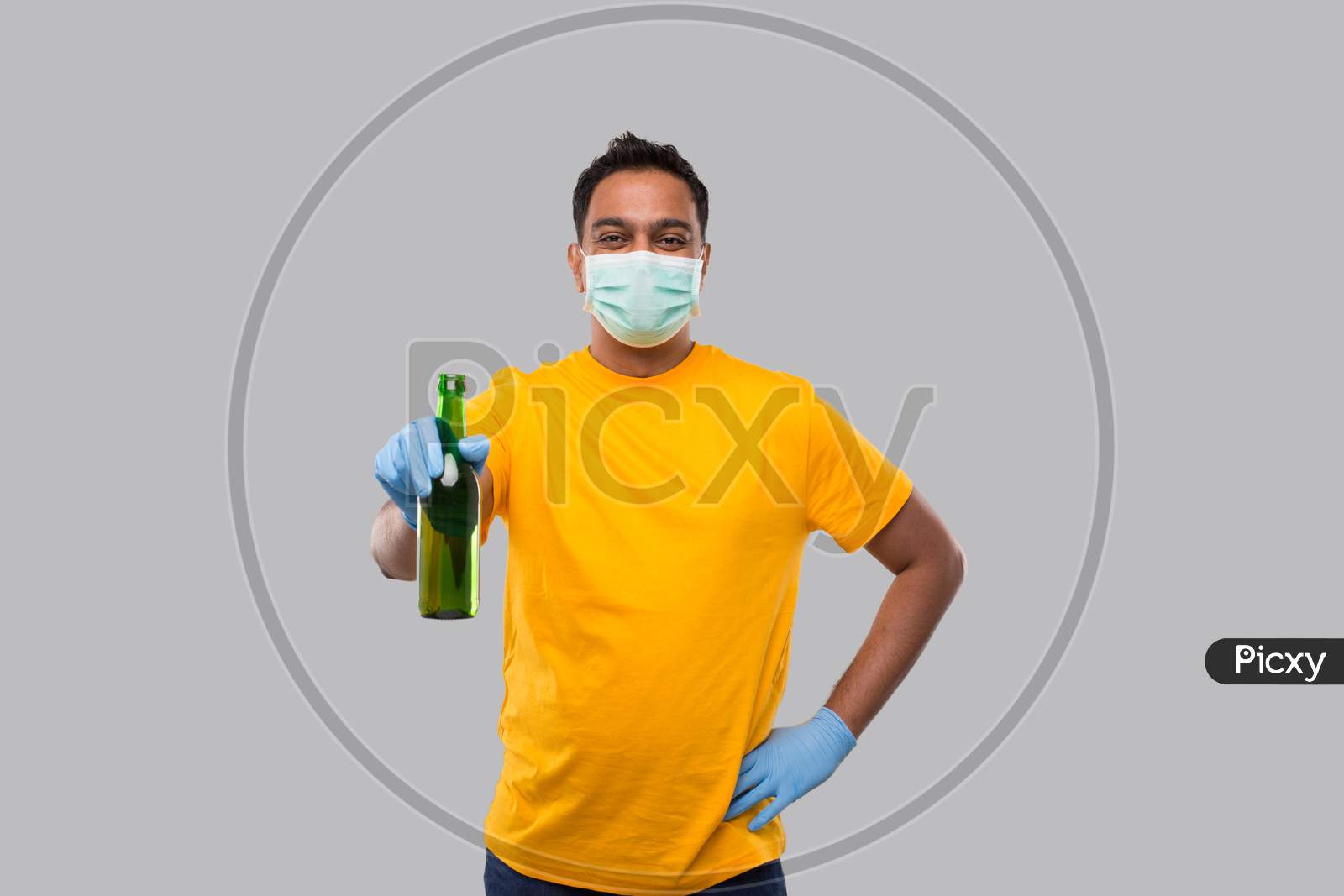 Indian Man Holding Beer Bottle Wearing Medical Mask And Gloves Isolated.