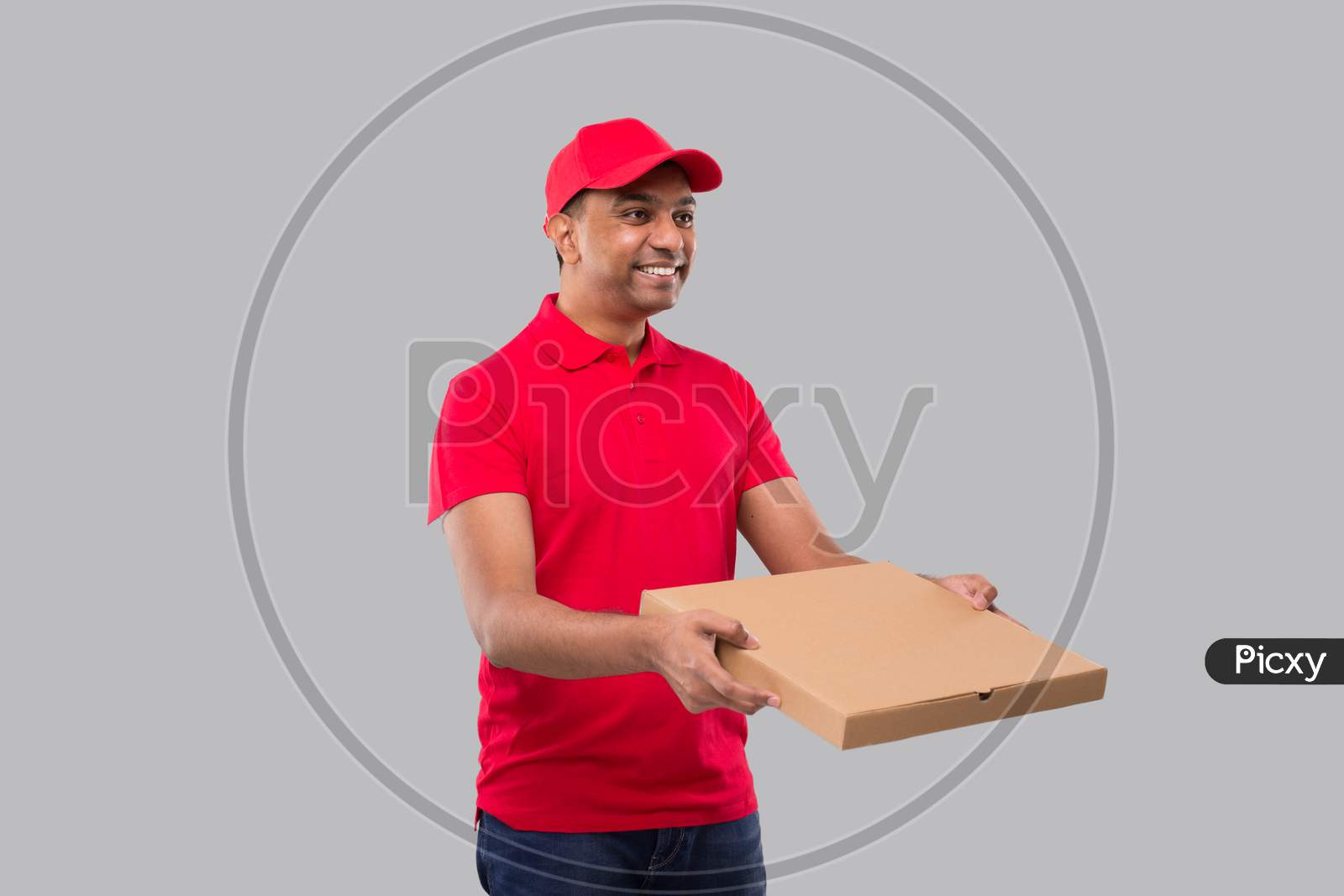 Delivery Man Pizza Box In Hands Watching Side Isolated. Red Tshirt Indian Delivery Boy.