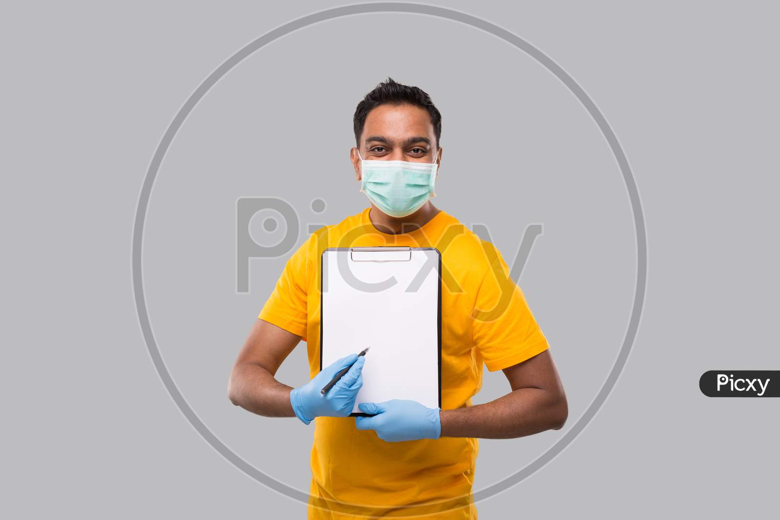 Indian Man Pointing At Clipboard Wearing Medical Mask And Gloves Watching In Camera. Indian Delivery Boy Clipboard