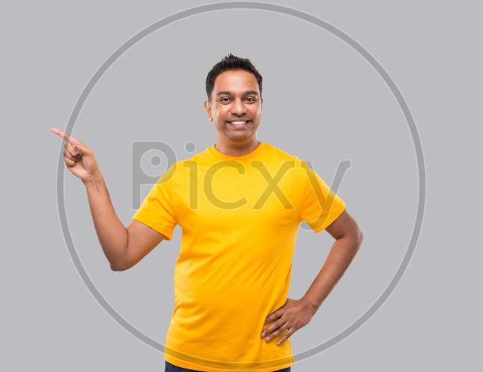 Indian Man Pointing To Side Smilling Isolated.