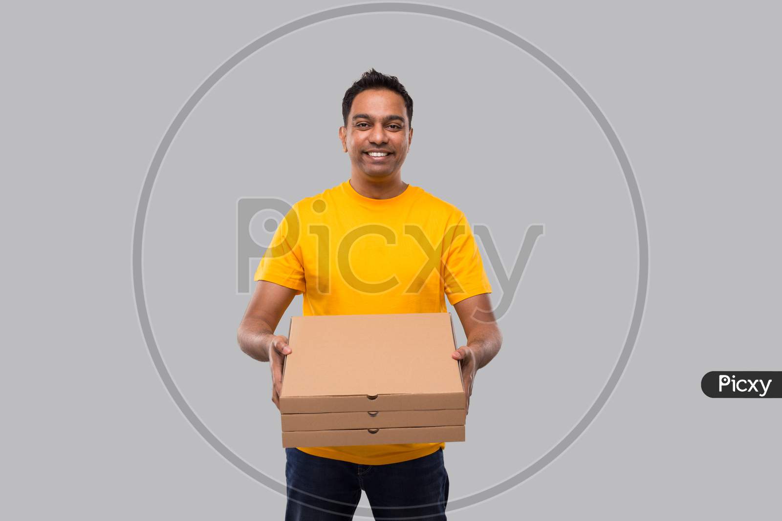 Delivery Man Three Pizza Box In Hands Isolated. Yellow Tshirt Indian Delivery Boy. Man With Pizza In Hands