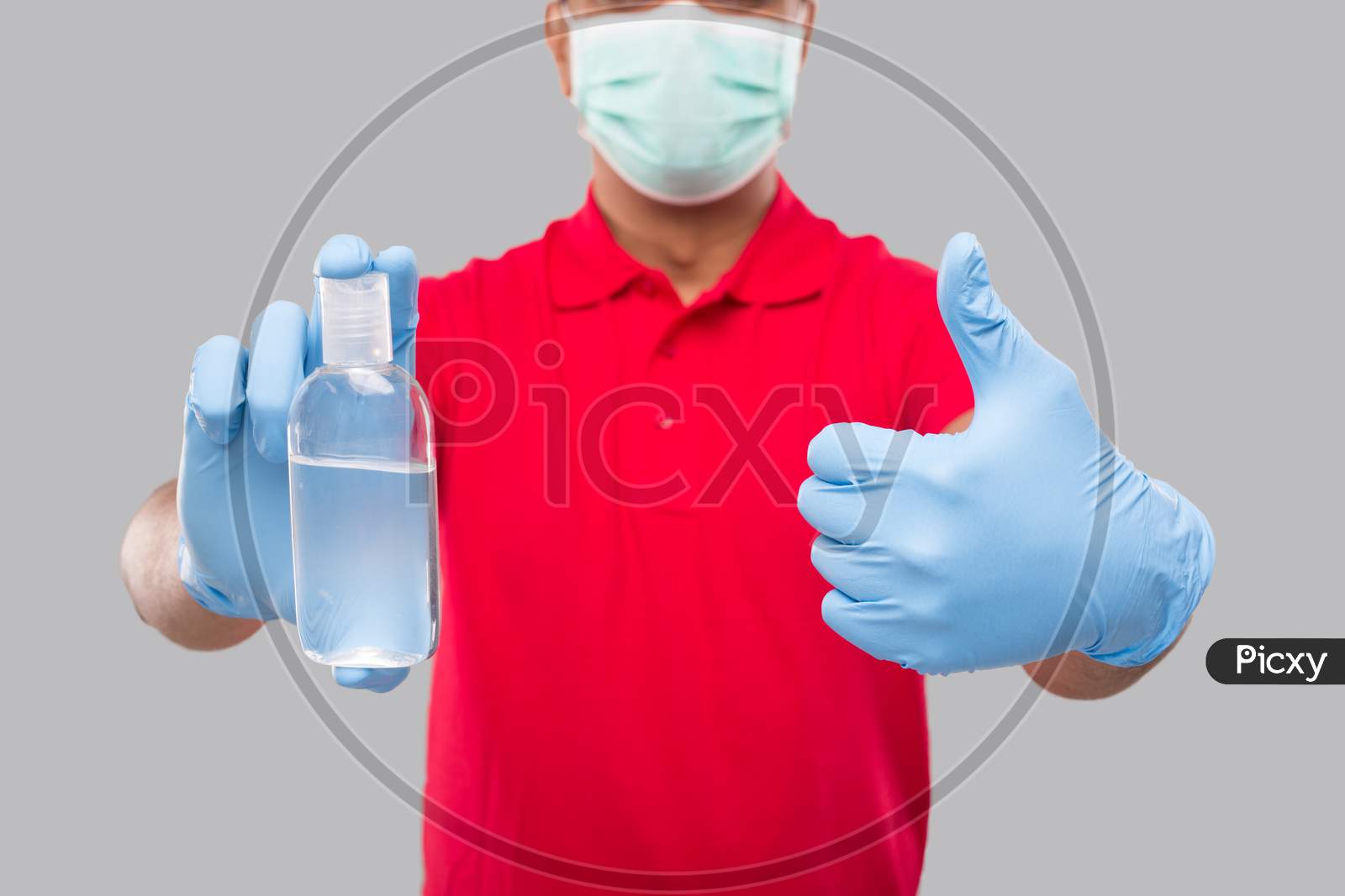 Delivery Man Showing Hands Sanitizer And Thumb Up Wearing Medical Mask And Gloves Isolated. Indian Delivery Boy Holding Hand Antiseptic Close Up