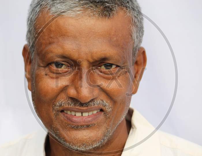 Smiling Indian senior man face portrait on white background.