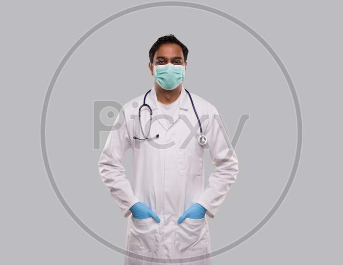 Male Doctor Wearing Medical Mask And Gloves Standing Isolated. Indian Man Doctor Medical Workwear. Medical Concept