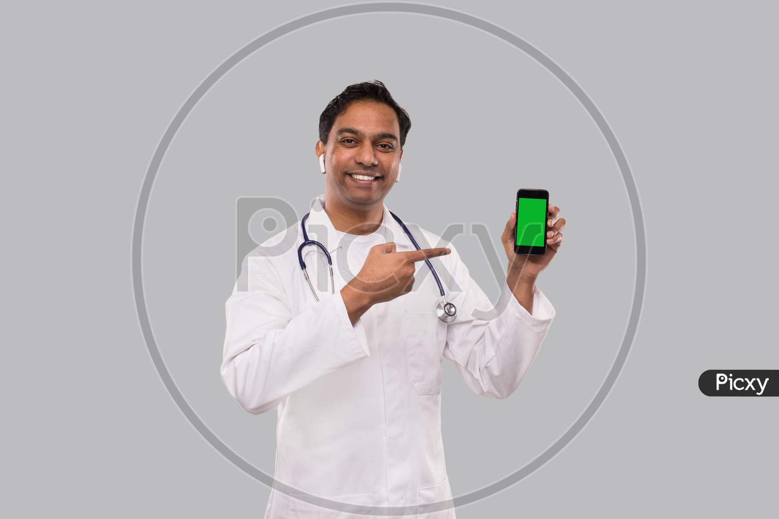 Doctor Pointing At Phone Isolated. Indian Man Doctor Phone Green Screen In Hands