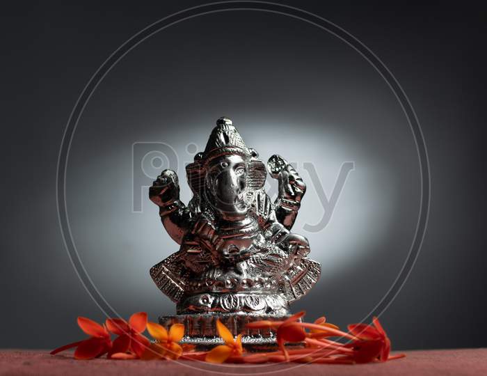 Ganesha / Ganapathi idol decorated with flowers and interesting background for Ganesh Chaturthi
