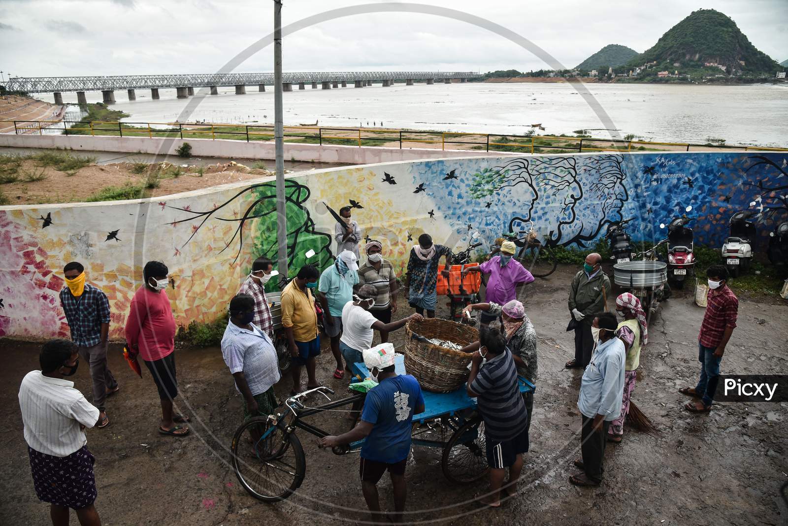 Fishermen sell fish which they caught from the swollen Krishna river following the release of surplus water from the Prakasam Barrage in Vijayawada.