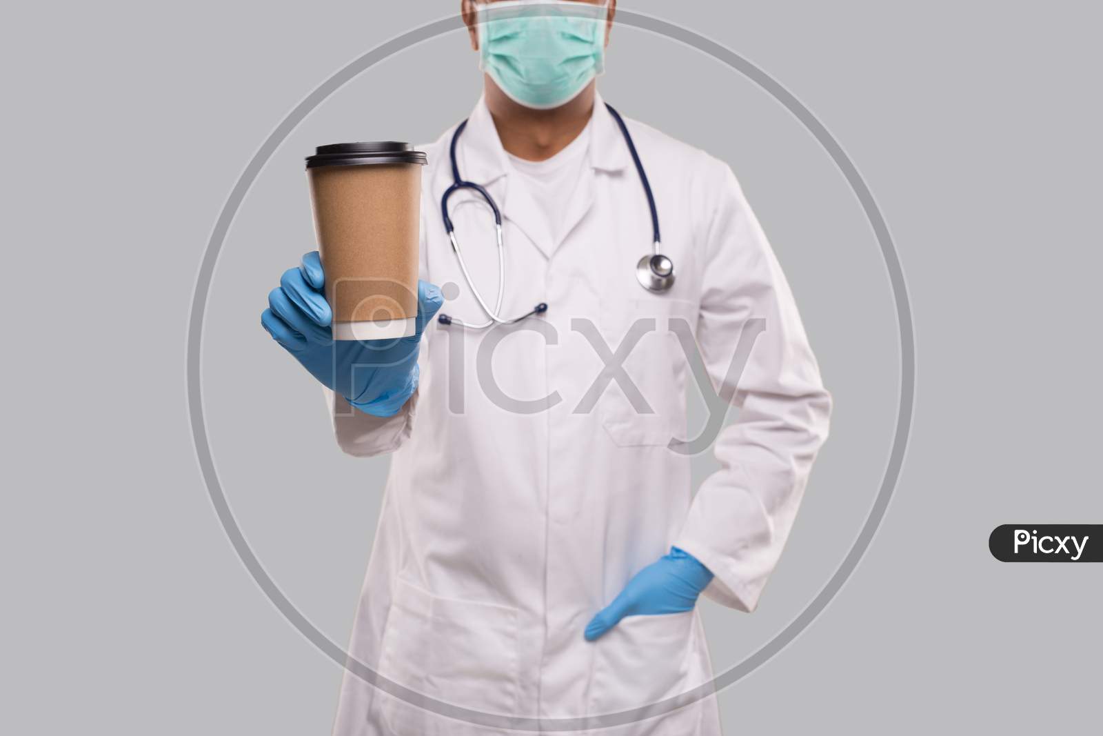 Indian Man Doctor Showing Coffee Take Away Cup Wearing Medical Mask And Gloves Close Up Isolated. Indian Doctor Holding Coffee To Go Cup.
