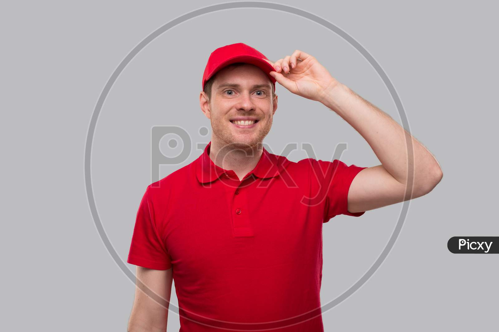 Delivery Man Smiling Holding Hat Portrait. Delivery Boy In Red Uniform