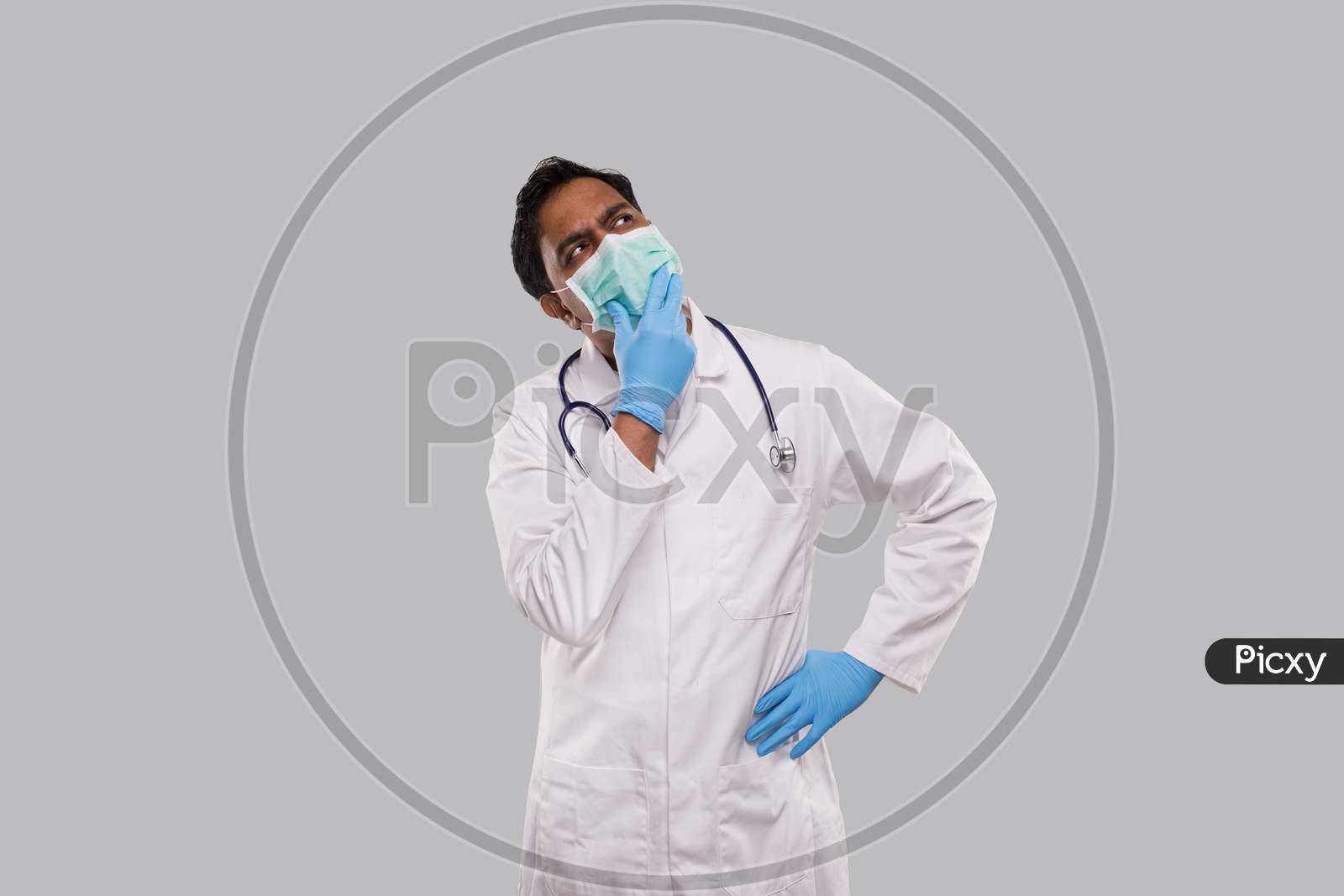 Indian Man Doctor Thinking Sign Wearing Medical Mask And Gloves. Doctor Watching Up. Isolated