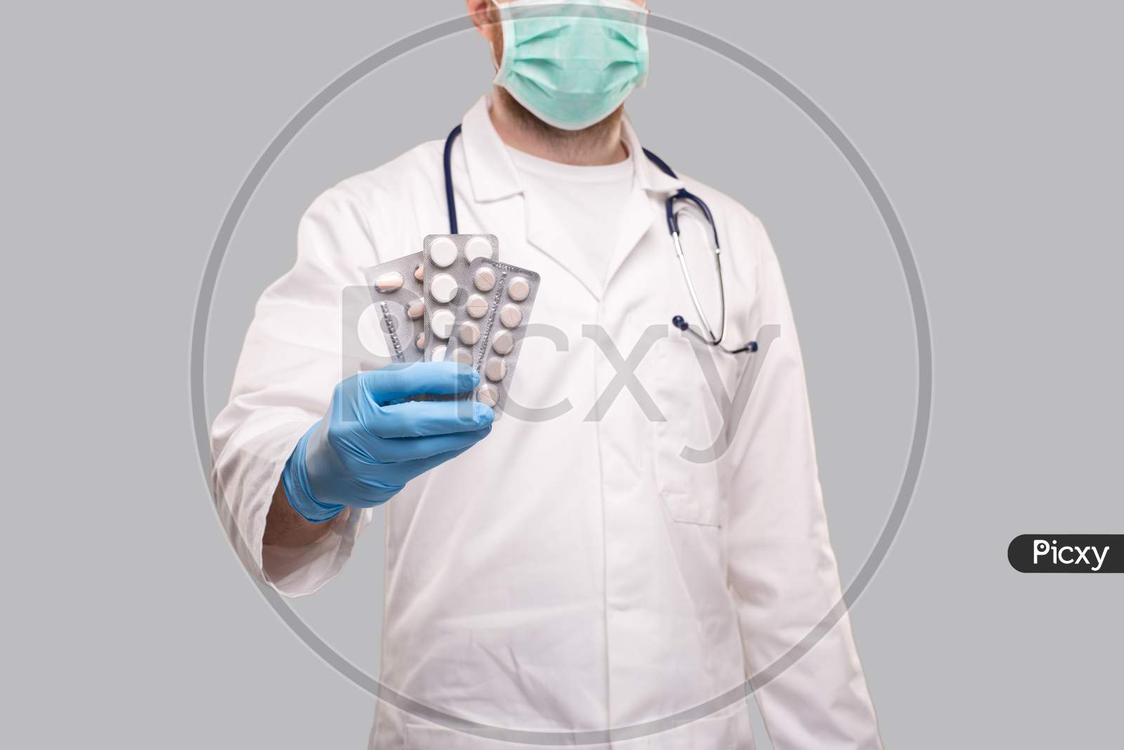 Man Doctor Showing Pills Wearing Medical Mask. Doctor Holding Tablets. Corona Virus Concept. Pills Close Up. Focus On Tablets