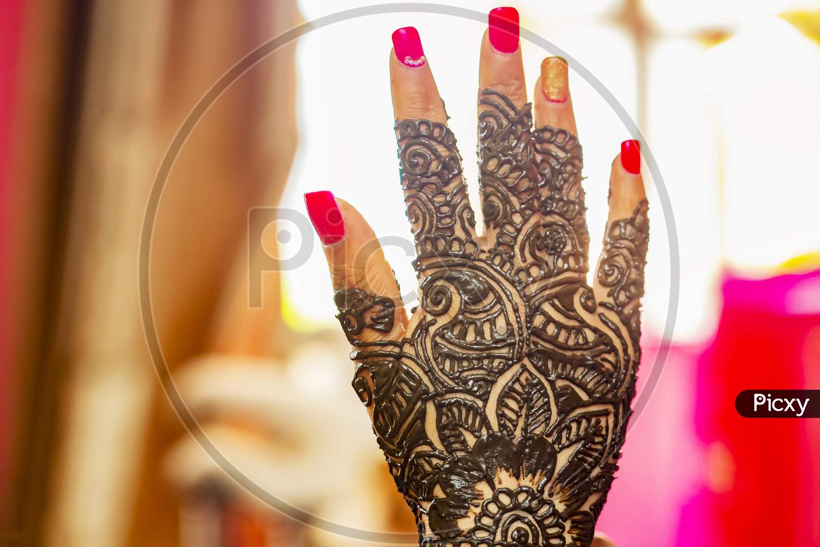 Bride's hand with henna design on wedding eve.