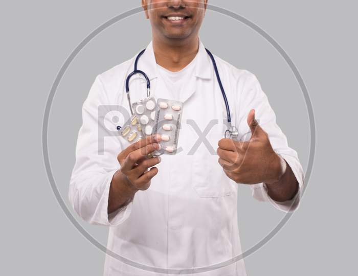 Man Doctor Showing Pills Thumb Up Close Up. Doctor Holding Tablets. Indian Man Doctor Isolated.