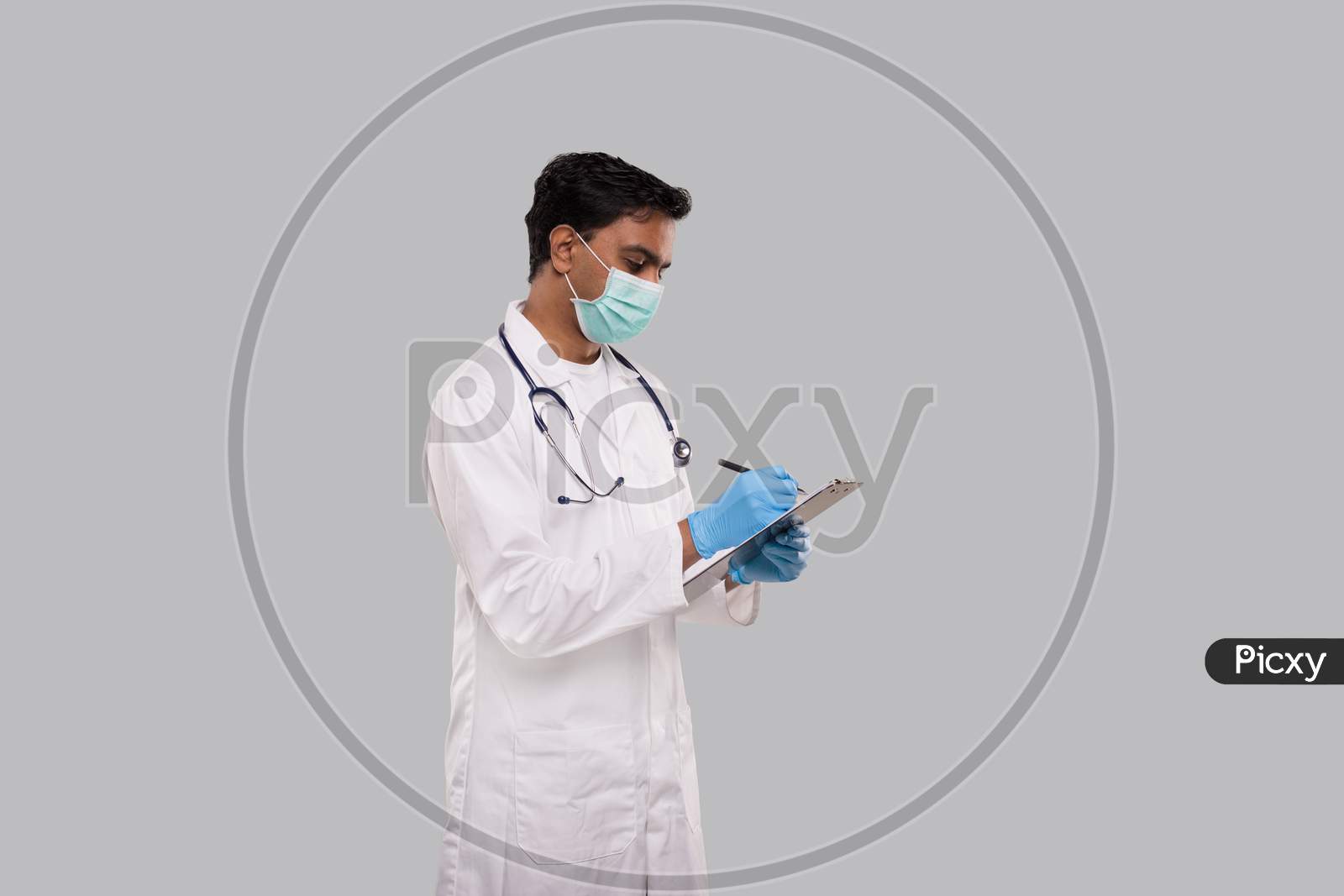 Doctor Writing In Clipboard Wearing Medical Mask And Gloves. Indian Man Doctor Clipboard Isolated