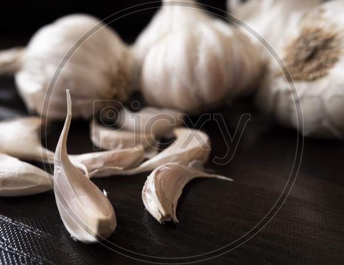 Closeup View Of Garlic'S & Cloves On Wooden Board