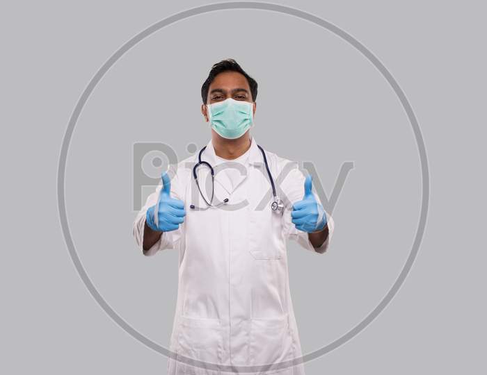 Doctor Showing Thumb Up Both Hands Smilling Wearing Medical Mask And Gloves. Indian Man Doctor Isolated