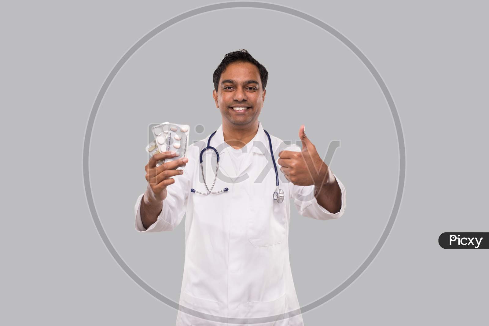 Man Doctor Showing Pills And Thumb Up. Doctor Holding Tablets. Indian Man Doctor Isolated.