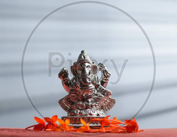 Ganesha / Ganapathi idol decorated with flowers and interesting background for Ganesh Chaturthi