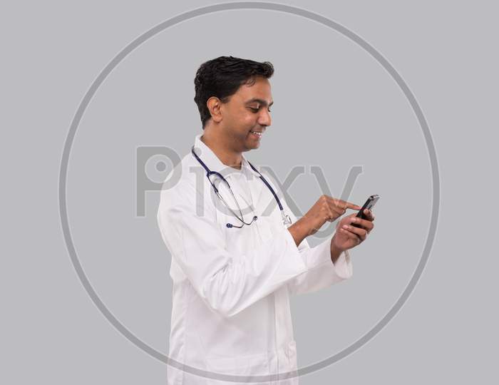 Doctor Chatting On The Phone Isolated. Indian Man Doctor With Phone. Online Medicine Tap