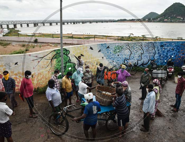 Fishermen sell fish which they caught from the swollen Krishna river following the release of surplus water from the Prakasam Barrage in Vijayawada.