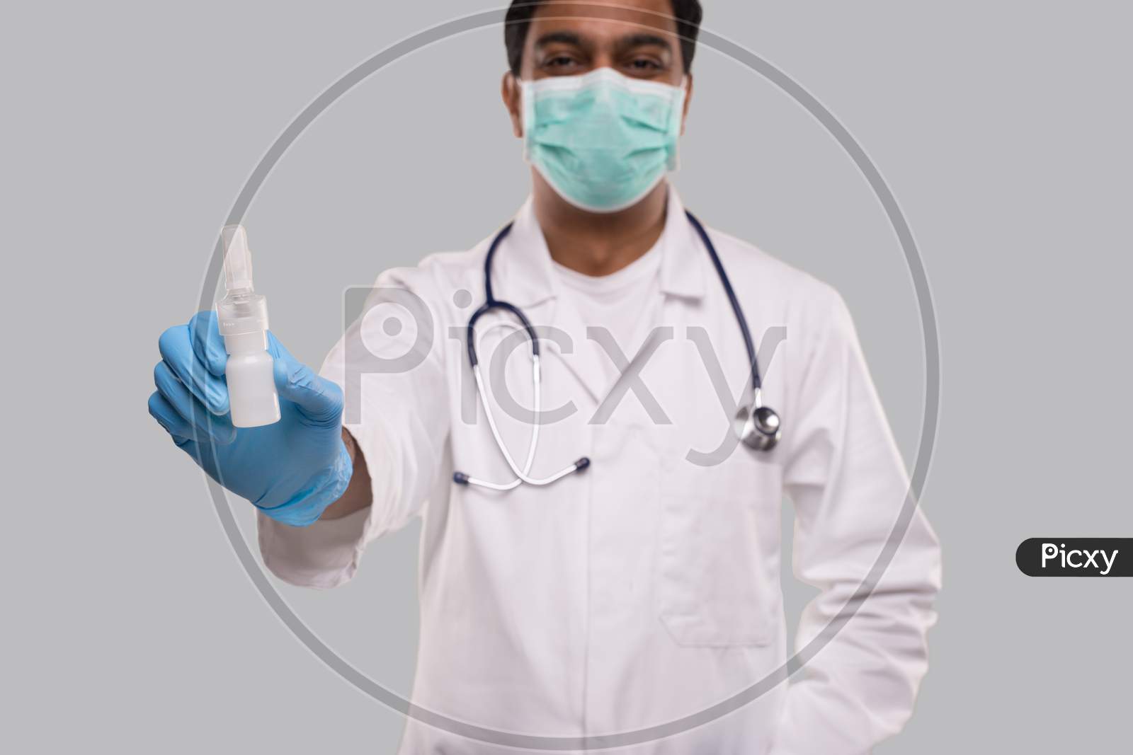 Doctor Showing Nose Spray Wearing Medical Mask And Gloves Close Up. Indian Man Doctor Nasal Spray. Corona Virus Concept. Isolated