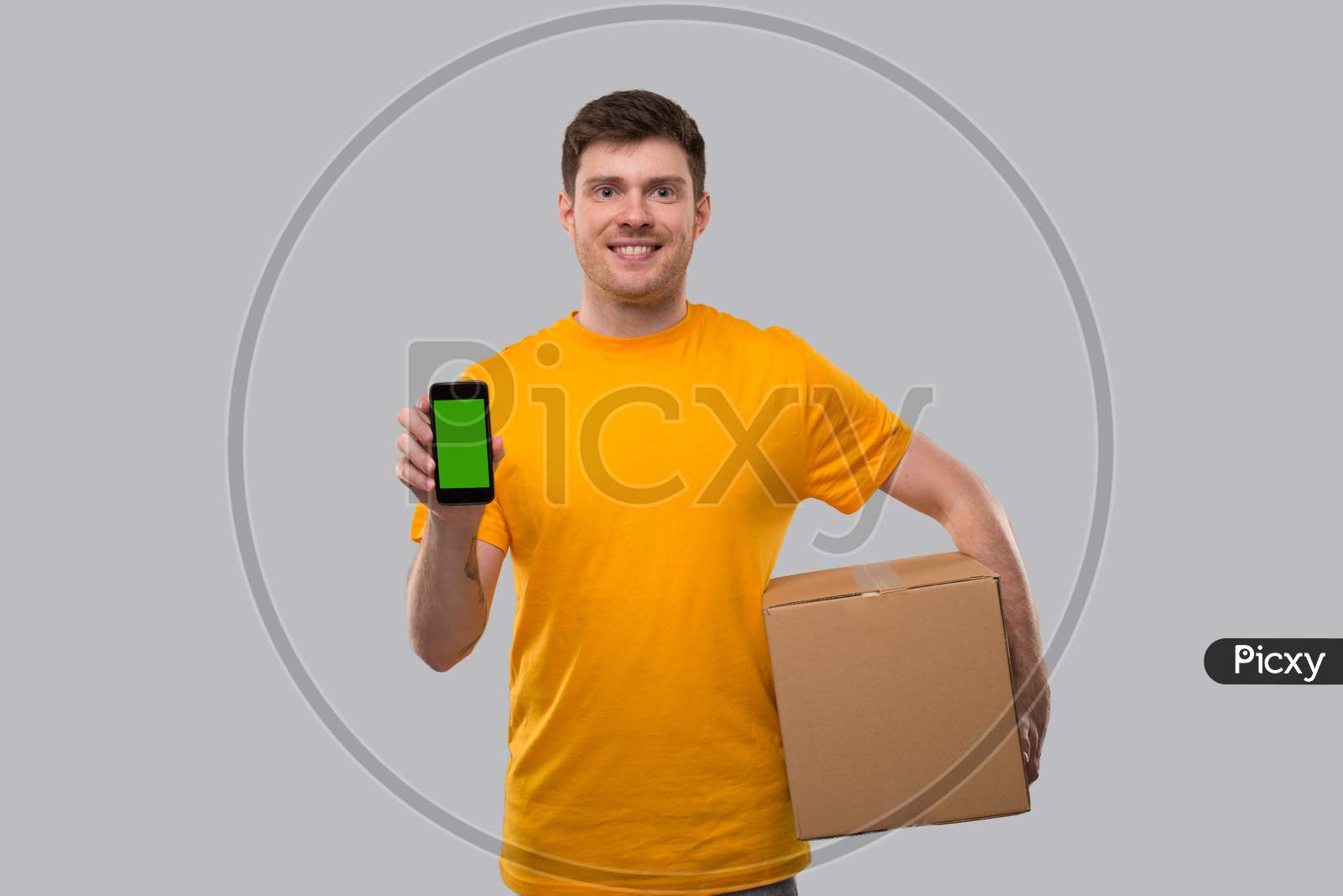 Delivery Man Showing Phone Holding Box. Phone Green Screen. Delivery Boy Smiling. Man With Parcel In Hands