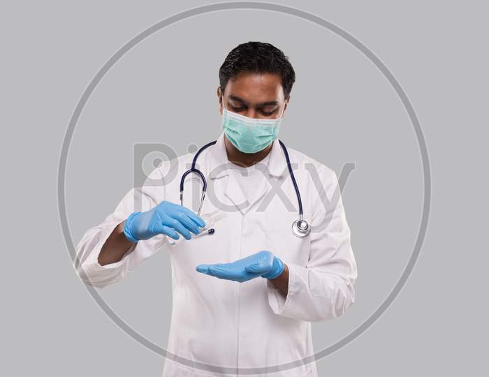 Doctor Using Hands Sanitizer Wearing Medical Mask And Gloves. Indian Man Doctor Holding Hands Wash Antiseptic. Corona Virus Concept. Isolated