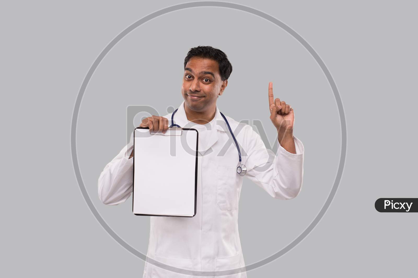 Doctor Pointing Up Clipboard Isolated. Indian Man Doctor Blank Clipboard In Hands. Male Doctor With Great Idea