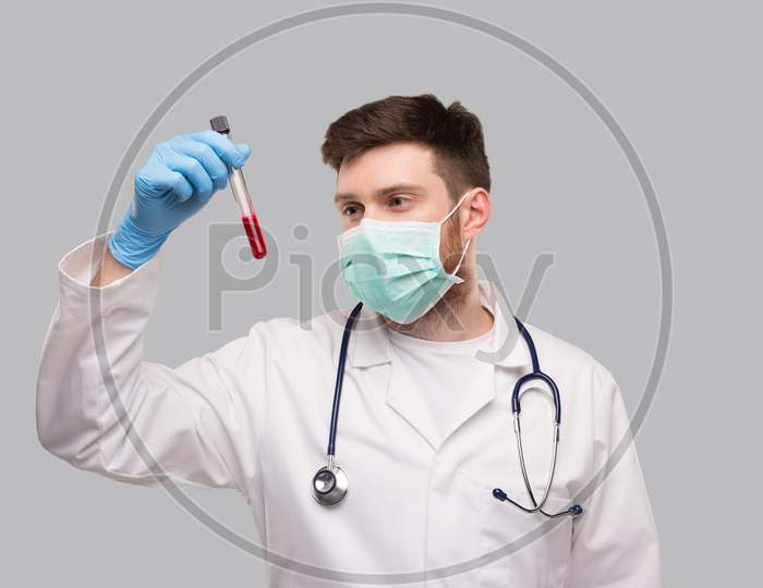 Male Doctor Checking Blood Analysis Wearing Medical Mask And Gloves. Portrait