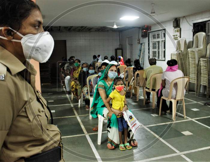Residents of a locality wait be screened at a camp, at a marriage hall, which has temporarily been converted into a coronavirus testing centre, in  Mumbai, India on July 17, 2020.