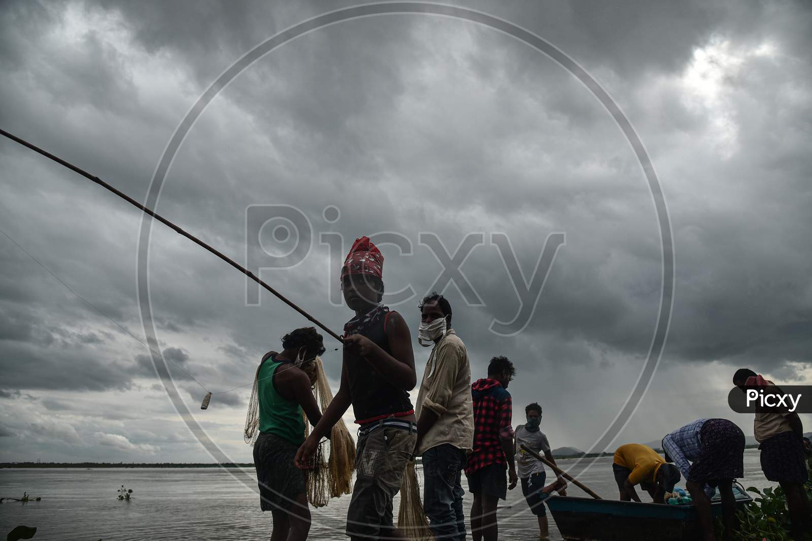 Fishermen prepare to catch fish in the swollen Krishna river following the release of surplus water from the Prakasam Barrage in Vijayawada.
