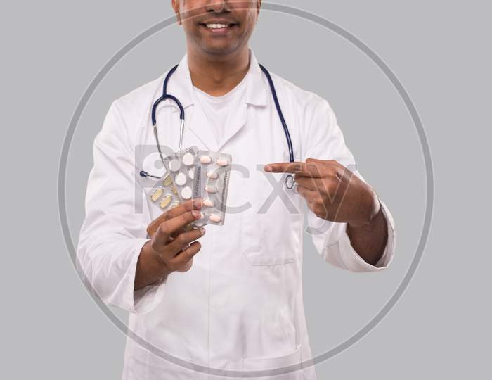Man Doctor Pointing At Pills Close Up. Doctor Holding Tablets. Indian Man Doctor Isolated.