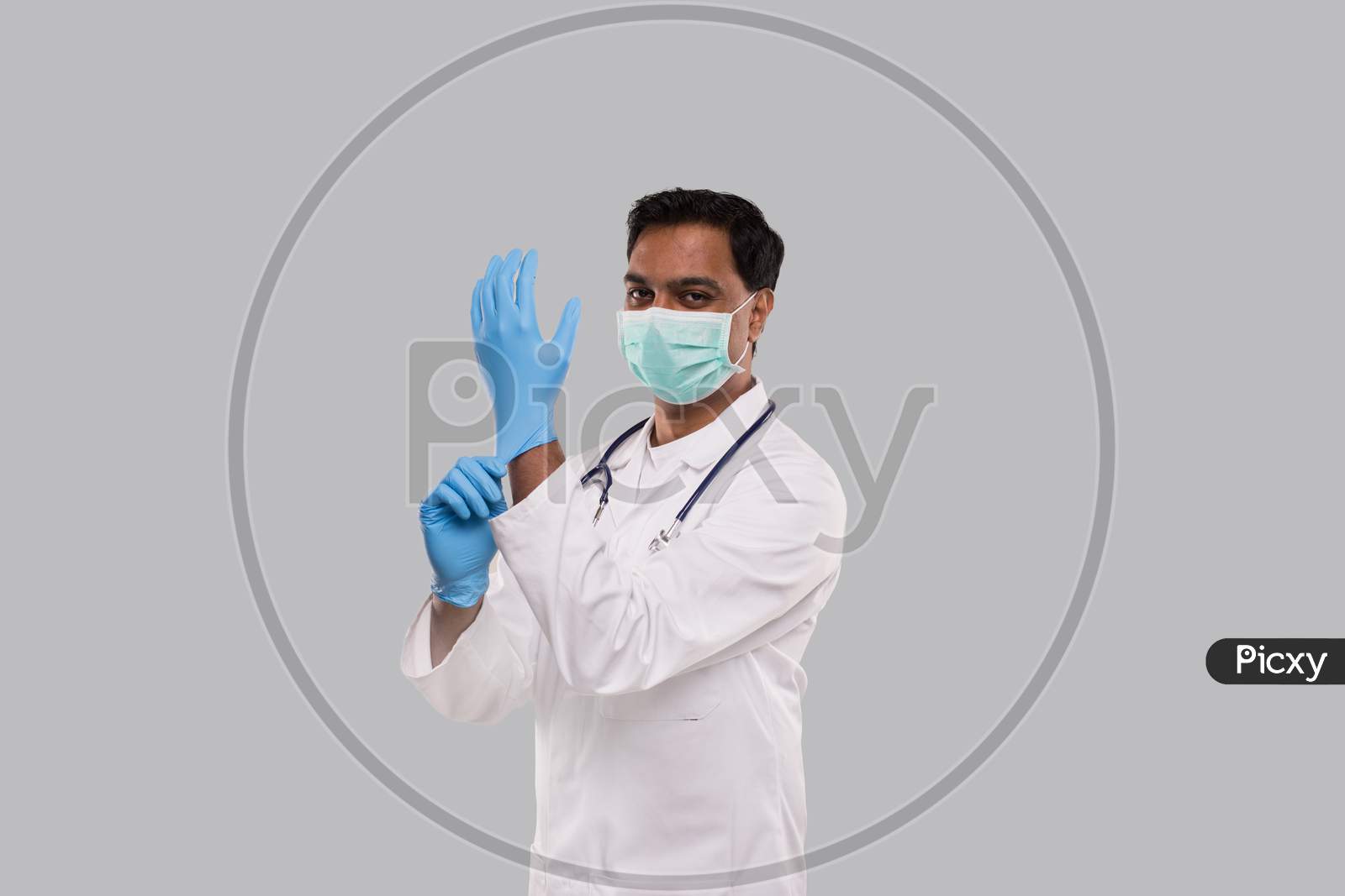 Doctor Puts On Gloves And Wearing Medical Mask Isolated. Indian Man Doctor Protection Mask Workwear. Medical Concept Corona Virus.