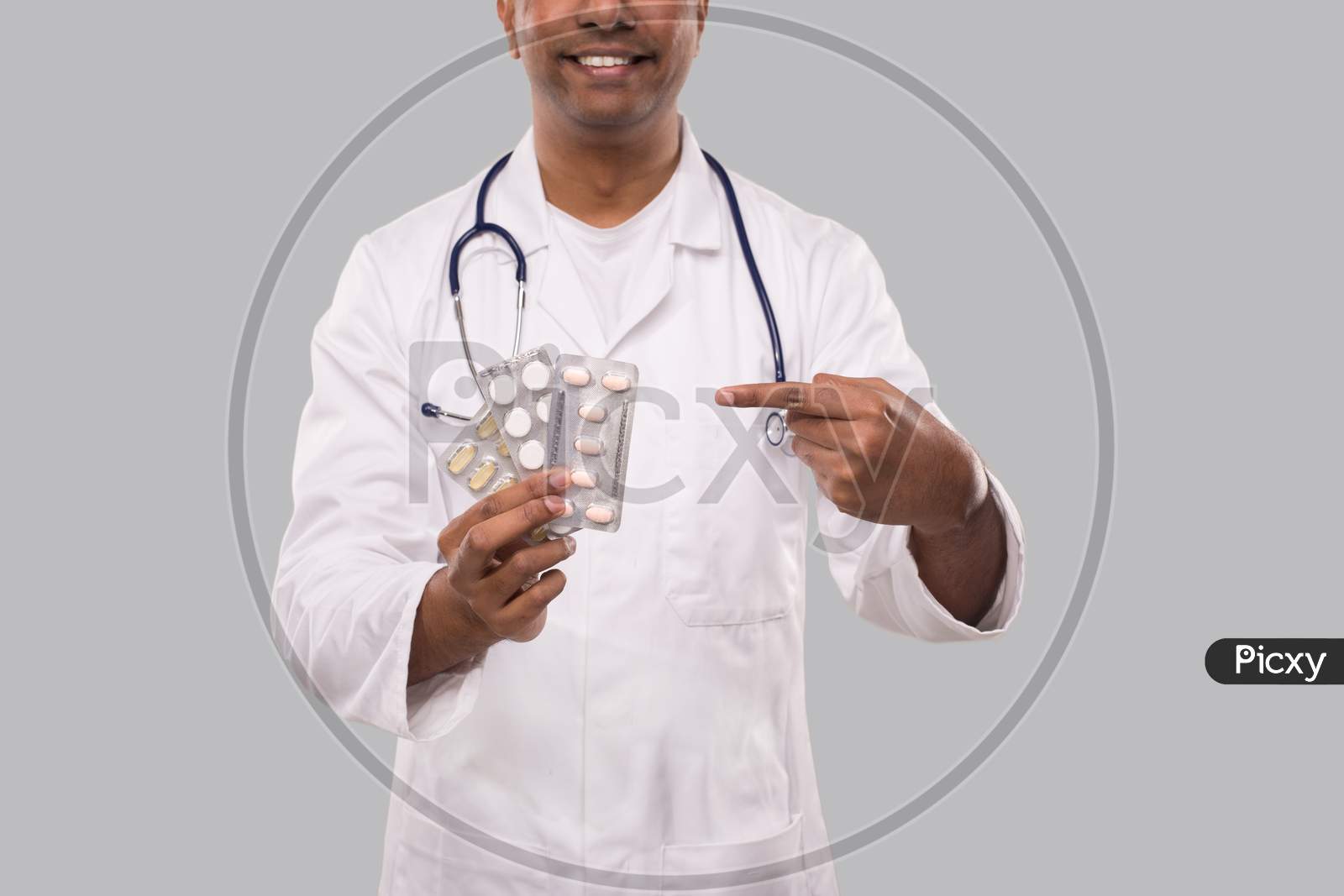 Man Doctor Pointing At Pills Close Up. Doctor Holding Tablets. Indian Man Doctor Isolated.