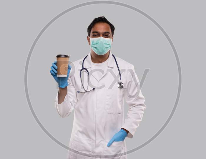 Indian Man Doctor Holding Coffee Take Away Cup Wearing Medical Mask And Gloves Isolated. Indian Doctor Holding Coffee To Go Cup.