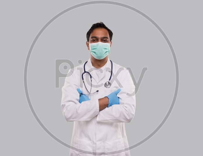 Doctor Wearing Medical Mask And Gloves Isolated. Indian Man Doctor Hands Crossed Medical Concept.