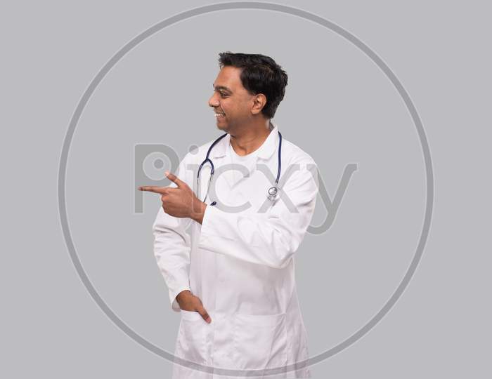 Indian Man Doctor Pointing To Side And Watching To Side. Isolated