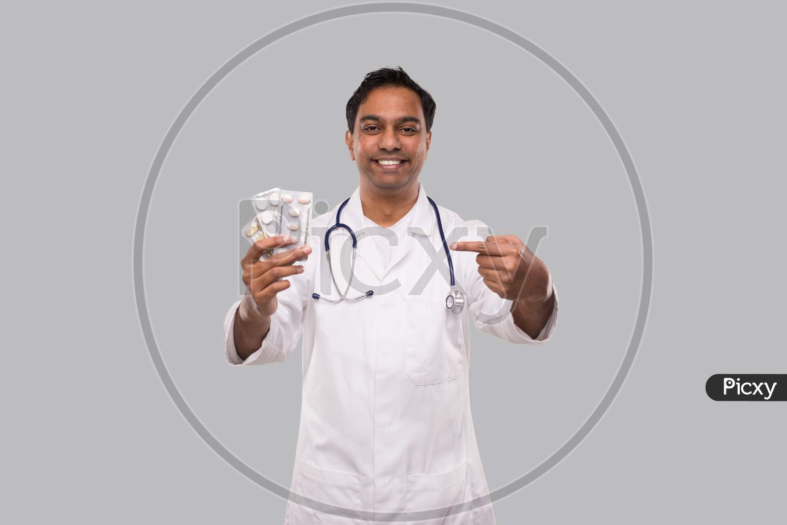 Man Doctor Pointing At Pills. Doctor Holding Tablets. Indian Man Doctor Isolated.
