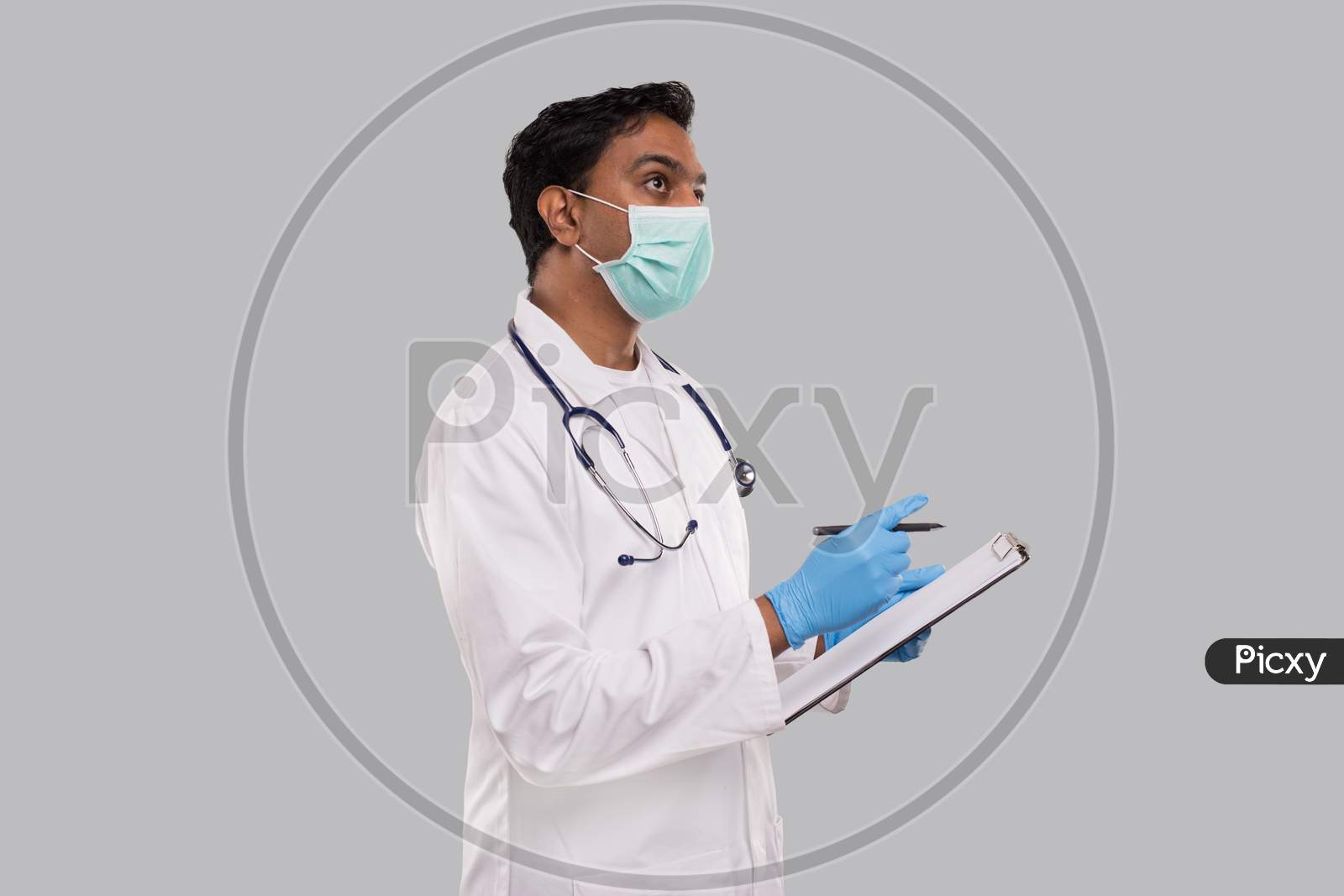 Doctor Writing Down Good Idea In Clipboard Wearing Medical Mask And Gloves. Indian Man Doctor Clipboard Isolated
