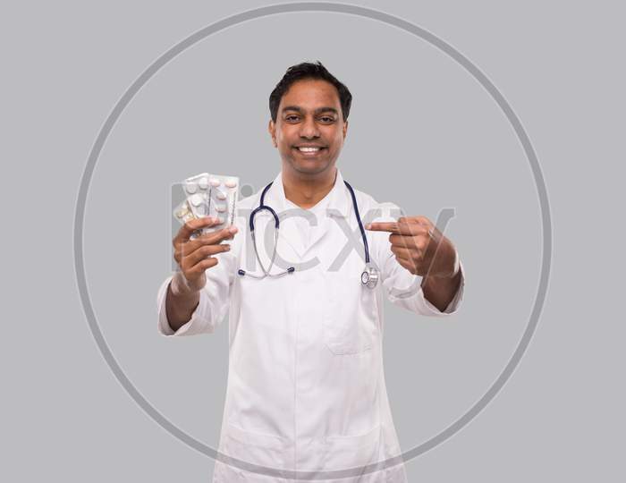 Man Doctor Pointing At Pills. Doctor Holding Tablets. Indian Man Doctor Isolated.