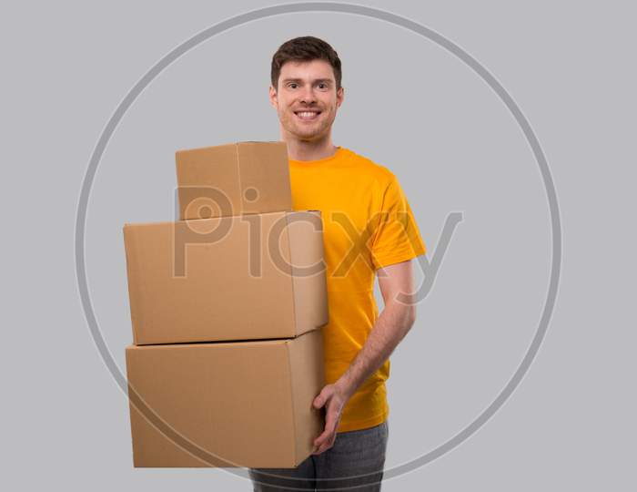 Delivery Man Holding Carton Boxes. Delivery Boy Smiling With Boxes In Hands