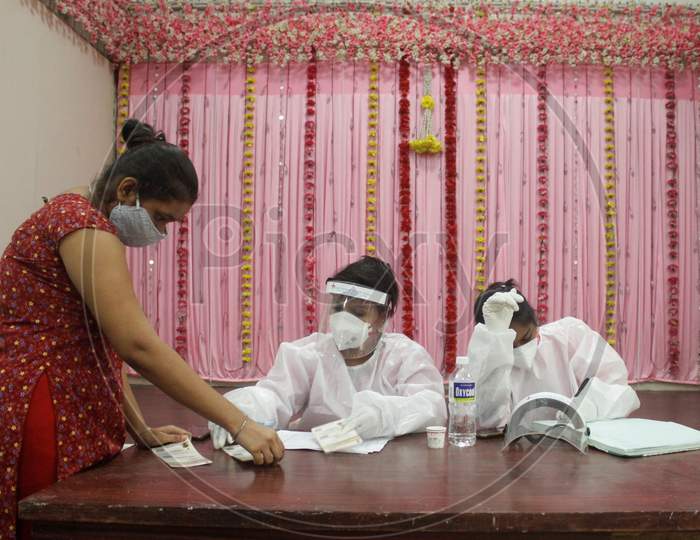 Heathcare workers wearing PPE suits takes down the details of a resident during a check up camp, at a marriage hall, which has temporarily been converted into a coronavirus testing centre, in Mumbai, India on July 17, 2020.